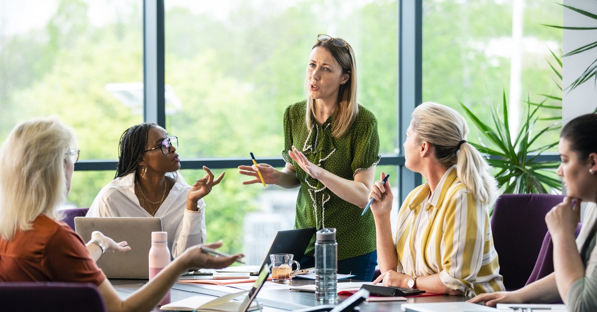 Company's team is in a meeting to communicate tips for prioritization of projects and setting clear expectations for communication protocols to help with managing increased demand for the summer surge.